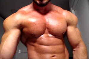 Powerful bodybuilder showing his sculpted chest and abs on live webcam