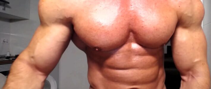 Muscular man showing abs on webcam